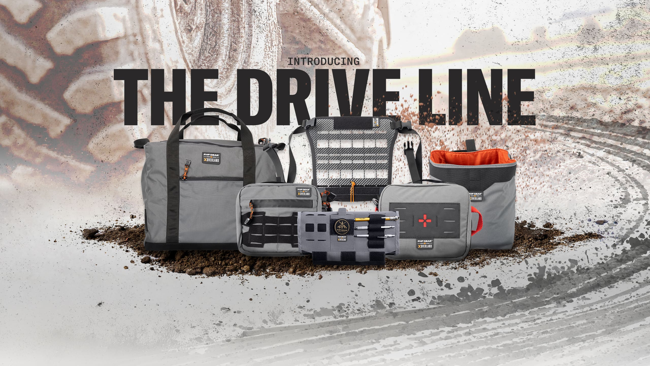 A collection of gray FHF Gear storage bags and overlanding organizers arranged on dirt, with the text INTRODUCING THE DRIVE LINE overlaid above them.